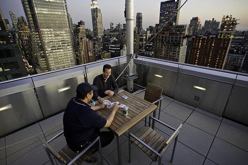 Nice deal. Michael Cohen and a friend play a game of poker on a communal deck of the Orion building 30 stories above Times Square. The Orion, a condo community, soars 60 stories above 42nd Street, offering residents everything from a full-time concierge to a free morning breakfast. 